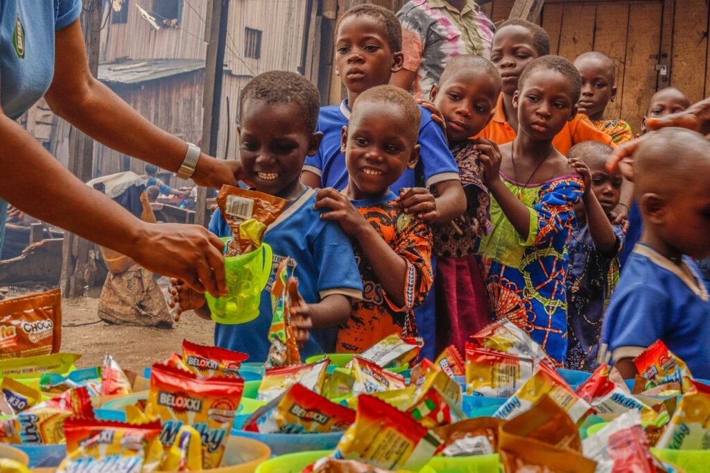 Mastering the First Impression: Your intriguing post title goes here Joyful children receiving food supplies from a volunteer in an outdoor setting.